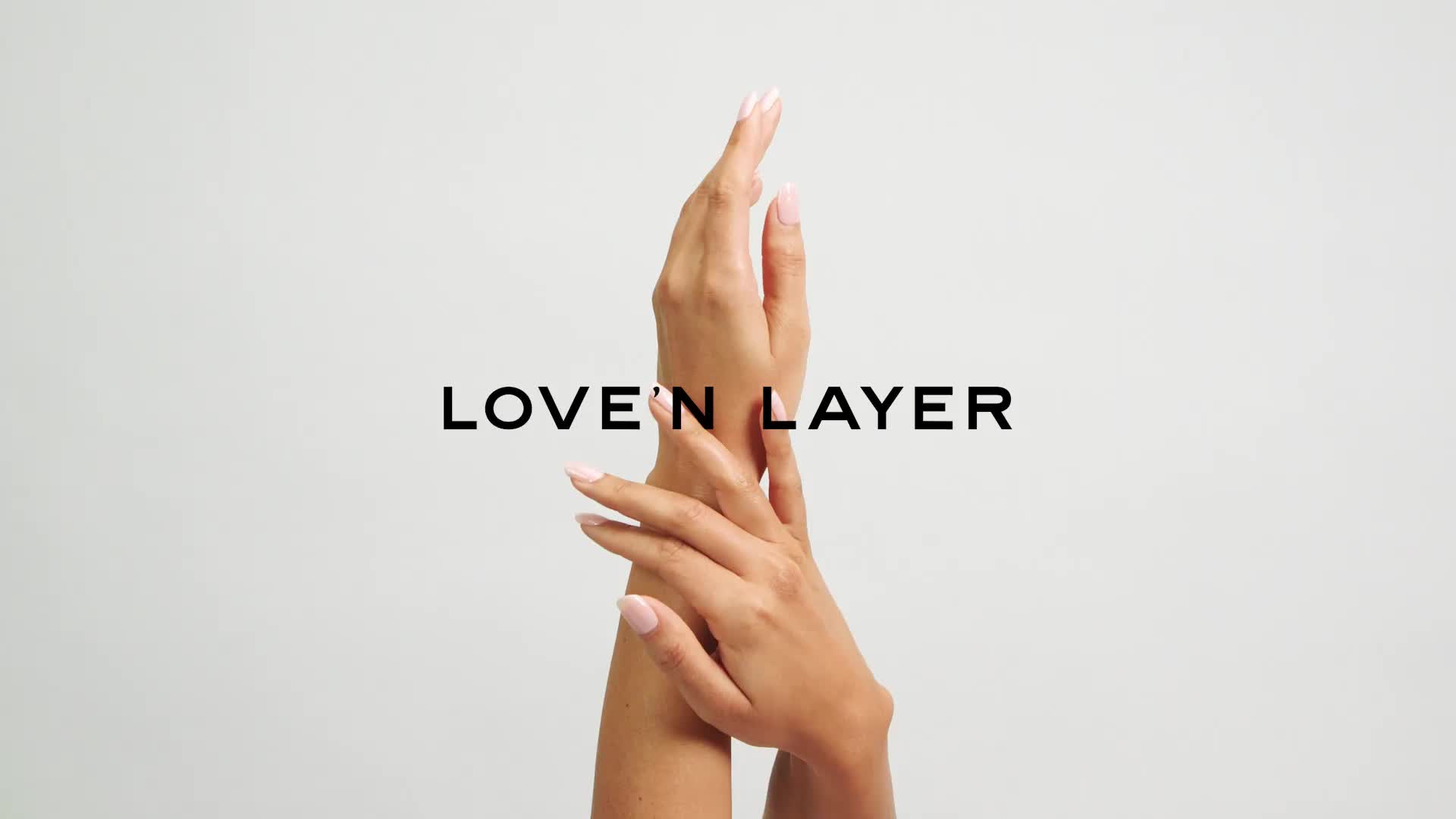 Kaksi kättä koskettavat toisiaan valkoisen taustan edessä, ja keskellä lukee "LOVE N LAYER".